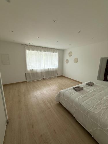 a white room with a bed and a window at Vertu'Ose in Morbier