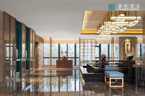 a lobby with a couch and a table and windows at Zhuhai Tangyi Hotel in Zhuhai