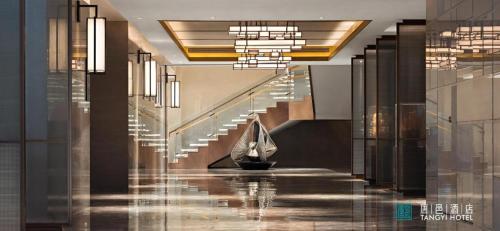 a hallway with stairs in a building with lights at Zhuhai Tangyi Hotel in Zhuhai