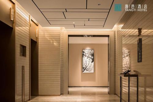 a hallway of a building with a door and a picture at Zhuhai Tangyi Hotel in Zhuhai