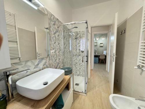 a bathroom with a white sink and a shower at A Casa di Laura in Ladispoli