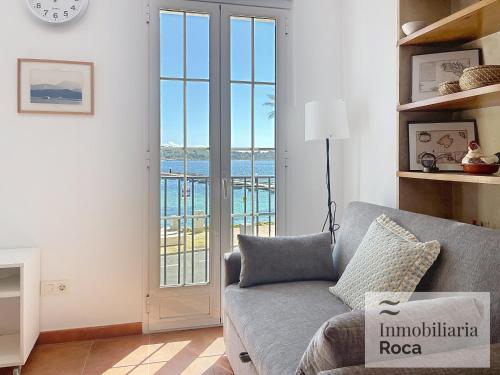 a living room with a couch and a view of the ocean at Roca Fornells, Maritim 53 - F275 in Fornells