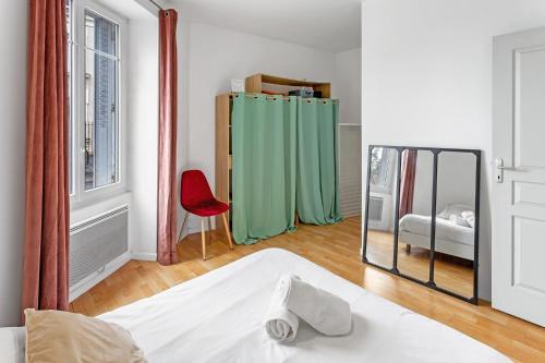 ヴェルトゥにあるLecour - Confortableのベッドルーム1室(鏡、ベッド1台、赤い椅子付)