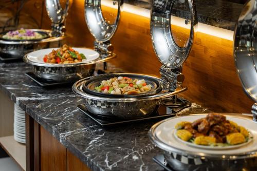 a buffet with several plates of food on a counter at Kindness Hotel - Kaohsiung Main Station in Kaohsiung