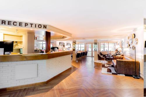 a lobby of a hotel with a reception counter at Eden Park Hotel Restaurant in Pont-lʼÉvêque