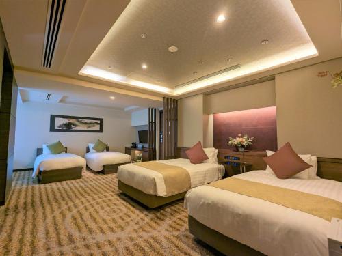 a hotel room with three beds in a room at Hotel Keihan Kyoto Grande in Kyoto