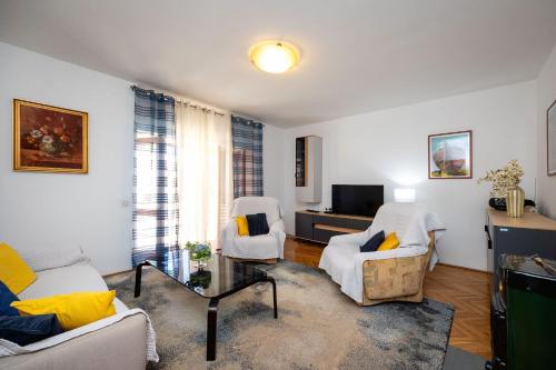 a living room with two chairs and a tv at House Zeljka in Podstrana