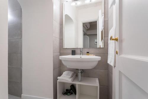 a white bathroom with a sink and a mirror at Rome as you feel - Grotta Pinta apartments in Rome