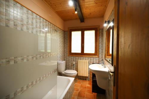 a bathroom with a tub and a toilet and a sink at YourHouse Lar de Lagos in Bueu