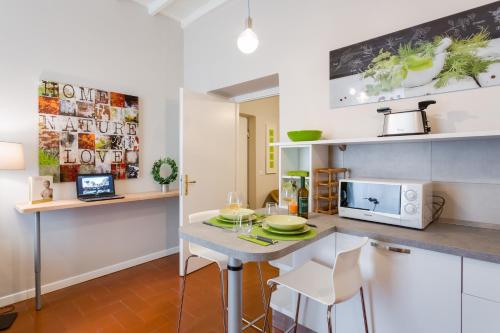 a kitchen with a table with chairs and a microwave at Rome as you feel - Grotta Pinta apartments in Rome