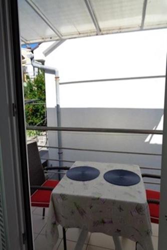 a table and chairs sitting on a balcony at Apartments Vlado in Njivice