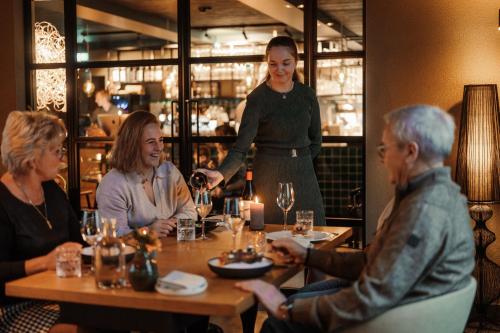a group of people sitting around a table in a restaurant at LUDIEK eten en slapen in Havelte