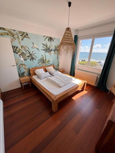 a bedroom with a bed and a large window at Villa face mer - Le Pouliguen in Le Pouliguen