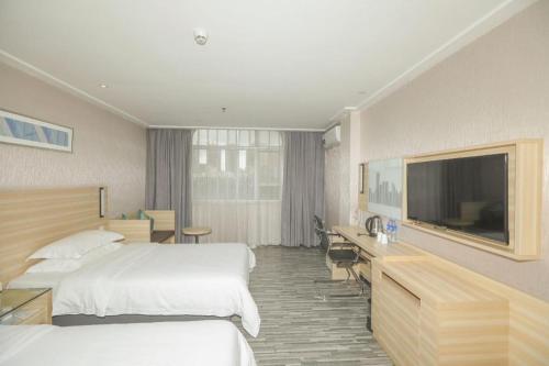 une chambre d'hôtel avec deux lits et une télévision à écran plat dans l'établissement City Comfort Inn Shenzhen Longhua District Government, à Tiantangwei