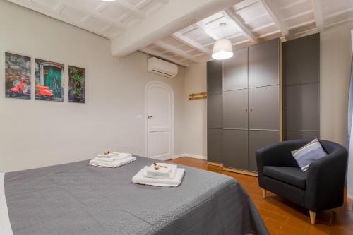 a bedroom with a bed and a black chair at Rome as you feel - Grotta Pinta apartments in Rome