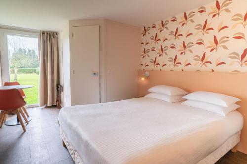 a bedroom with a large bed and a window at Eden Park Hotel Restaurant in Pont-lʼÉvêque