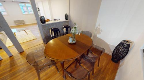 une salle à manger avec une table et des chaises en bois dans l'établissement F5 - Rue Dauphine, au Havre