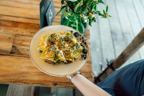 a person holding a bowl of food on a table at LUDIEK eten en slapen in Havelte