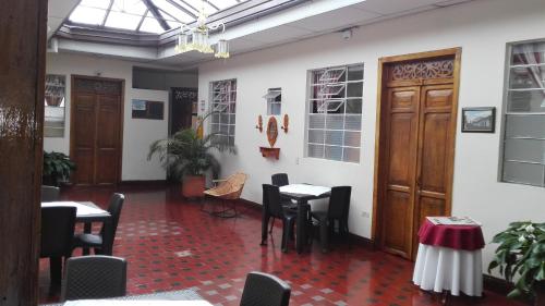 ein Restaurant mit Tischen und Stühlen in einem Zimmer in der Unterkunft Hotel Alcayata Colonial in Popayan