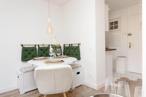 une salle à manger blanche avec une table et des chaises blanches dans l'établissement Cosy studio rénové - Proche de la mer - DI, à Menton