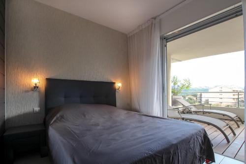 une chambre avec un lit et une grande fenêtre dans l'établissement NEPTUNE - Apartment 4 to 6 people - Port of Porto-Vecchio, à Porto-Vecchio