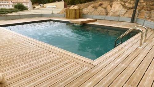 une grande piscine avec une terrasse en bois dans l'établissement NEPTUNE - Apartment 4 to 6 people - Port of Porto-Vecchio, à Porto-Vecchio
