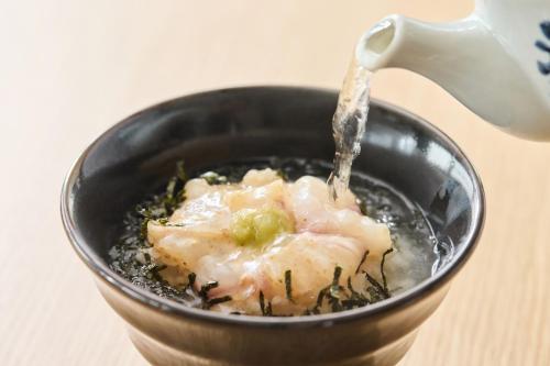 a bowl of food with water being poured into it at Kobe Motomachi Tokyu REI Hotel in Kobe