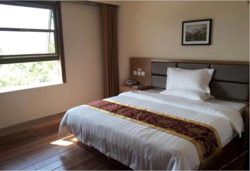 una camera da letto con un letto grande e una finestra di City 118 Hotel Aodele a Songguantun