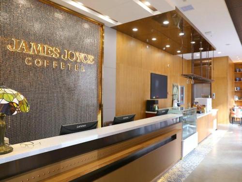 a lobby of a restaurant with a sign on the wall at James Joyce Coffetel Shenyang North Railway Station Qishan Road Metro Station in Shenyang