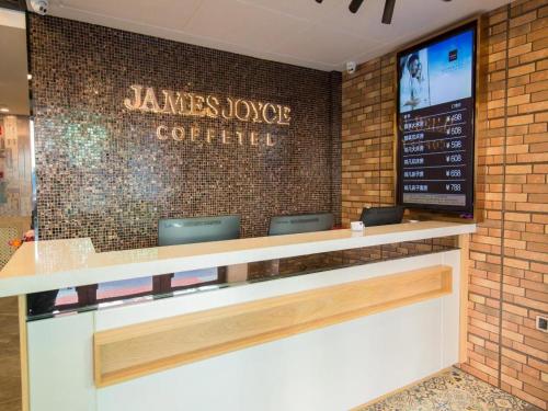 a restaurant counter with a sign on a brick wall at James Joyce Coffetel Harbin Central Street in Harbin