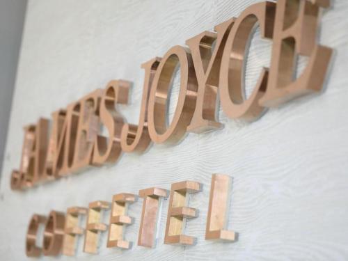 a sign that says love hanging on a wall at James Joyce Coffetel Shenyang North Railway Station Qishan Road Metro Station in Shenyang