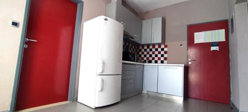 a kitchen with a white refrigerator and a red door at Villa Marijeta Hvar in Hvar