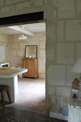 Habitación con mesa y pared de piedra. en Le Mas des Figuiers, en Arles