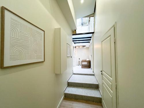 un couloir avec des escaliers et une photo sur le mur dans l'établissement Urban Flat 199 - Parisian 5 Bedroom Central Flat, à Paris