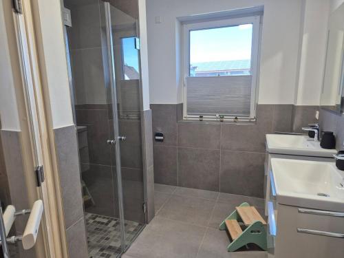 un bagno con doccia e lavandino di Traumhafte FeWo mit Garten und Sauna an der Küste a Dornum
