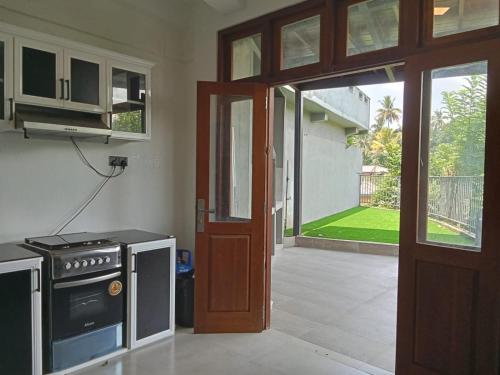 a kitchen with a stove and an open door at Riverside Bliss in Kandy