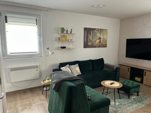 a living room with a green couch and a tv at Snow Lake in Divčibare