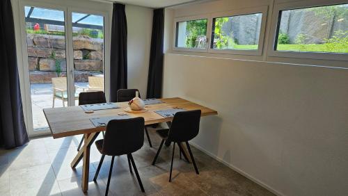 a dining room with a wooden table and chairs at Appartement Ersalin im schönen Domleschg in Sils im Domleschg