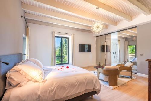 a bedroom with a large bed and a living room at Luxueux domaine au cœur des alpilles in Fontvieille