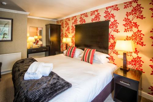 a hotel room with a large bed and a lamp at Woodlands in Windermere