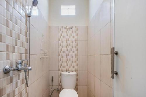 a small bathroom with a toilet and a shower at OYO Living 1877 Side Corner in Kanggraksan