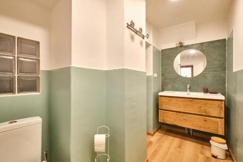 a bathroom with a sink and a mirror at Au 81 - Maison De Ville à Louer in Moirans