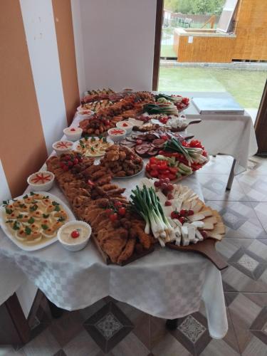 a long table with many plates of food on it at Casa Jazmin Covasna in Covasna
