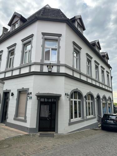 a white house with a black roof at Prosecco in Tecklenburg
