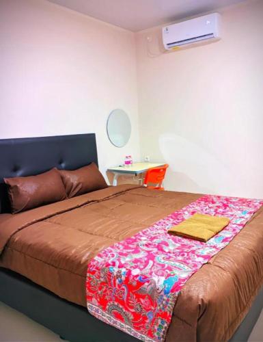 a bedroom with a bed with a blanket on it at Baltis Inn 3 Banyumanik in Semarang