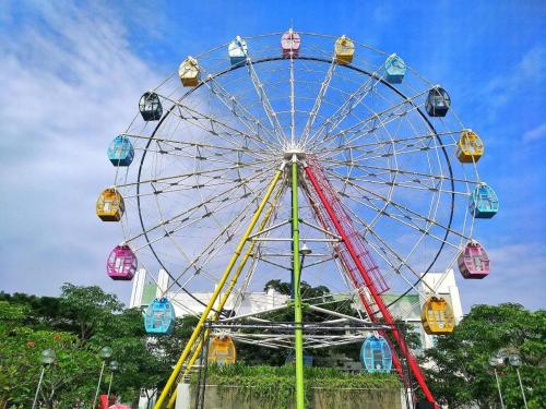 a ferris wheel in a park with a blue sky at Baltis Inn 3 Banyumanik in Semarang