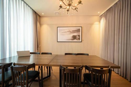 a dining room with a large wooden table and chairs at HOTEL D EDITION in Daejeon