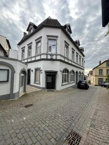 a large white house on a cobblestone street at Prosecco in Tecklenburg