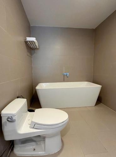 a bathroom with a toilet and a bath tub at Len's Hotel in Da Lat