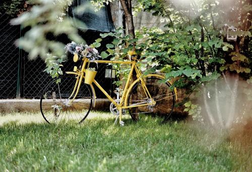 a yellow bike parked in the grass next to a fence at Holiday Home Casa Rondo in Bihać